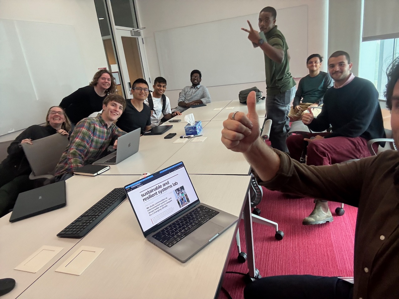 Members of the Sustainable and Resilient Systems Lab gathered around a conference table