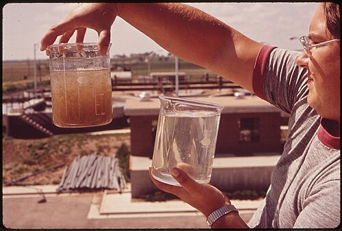 A water treatment technician compares untreated and treated water samples